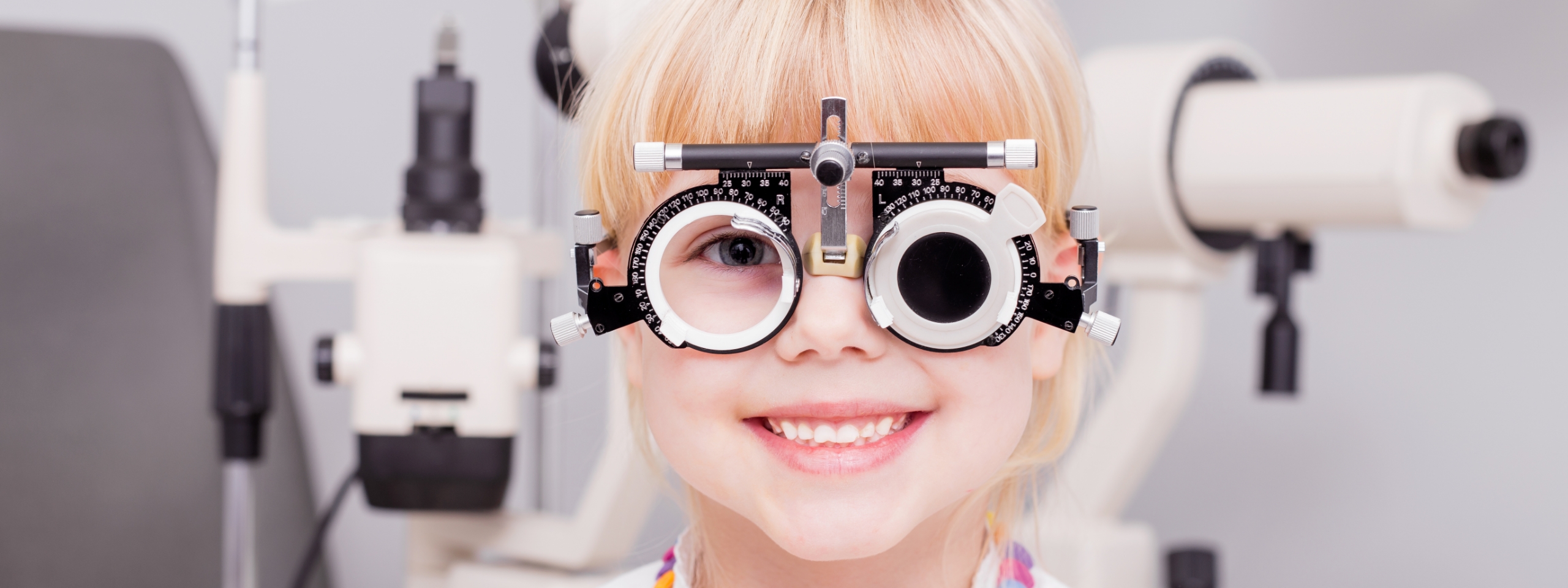 Mädchen sitzt vor Phoropter.